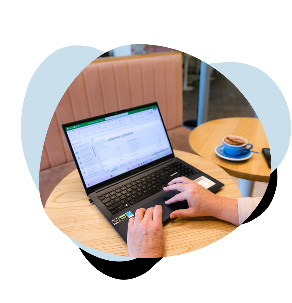 financial reports on laptop over a coffee in cafe