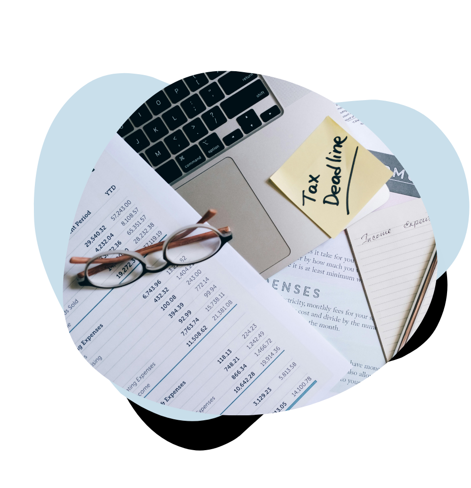 reading glasses and tax sheets and tax note on table